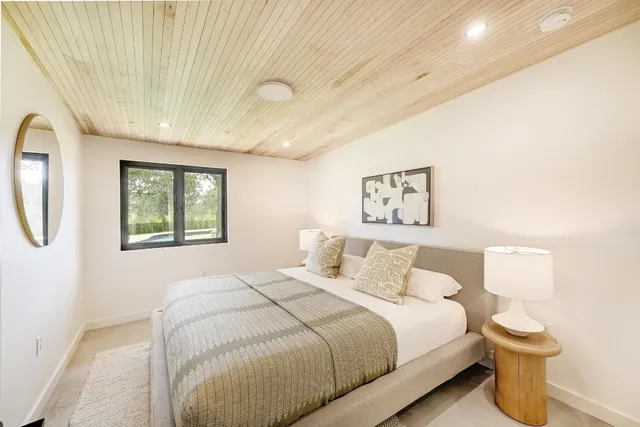 a bedroom with a bed and a painting on the wall