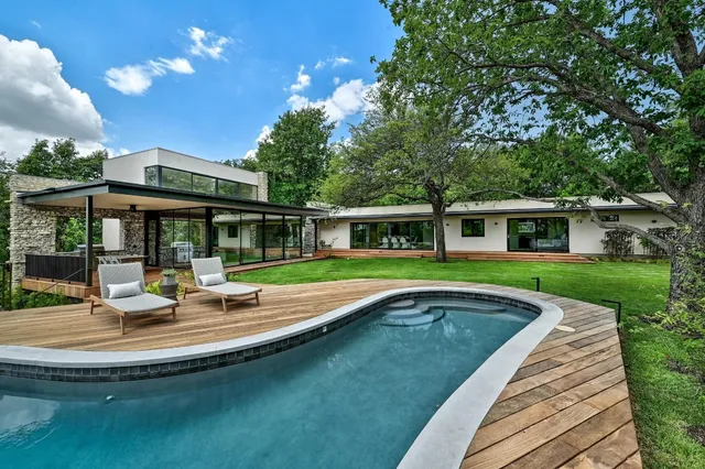 a view of house with swimming pool and porch with furniture