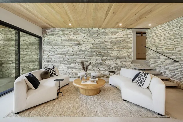 a living room with furniture and a floor to ceiling window