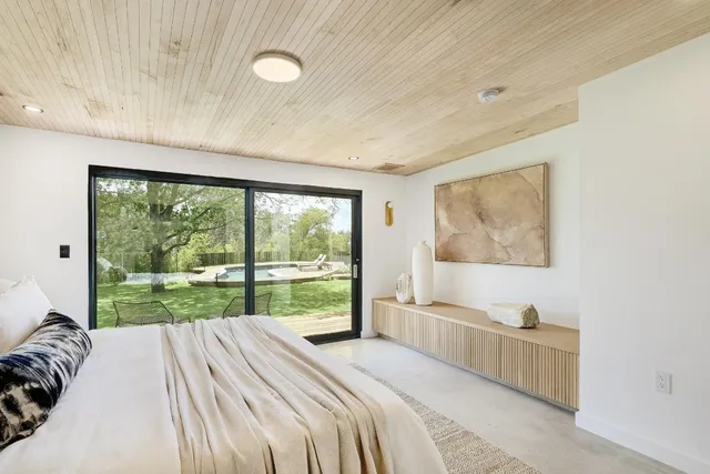 a bedroom with a bed and a large window