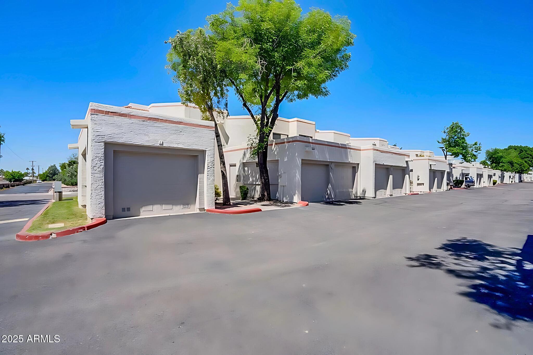 885 North Granite Reef Road, Unit 63 Scottsdale, AZ 85257 - Photo 19 of 23 a view of a house with a yard and garage