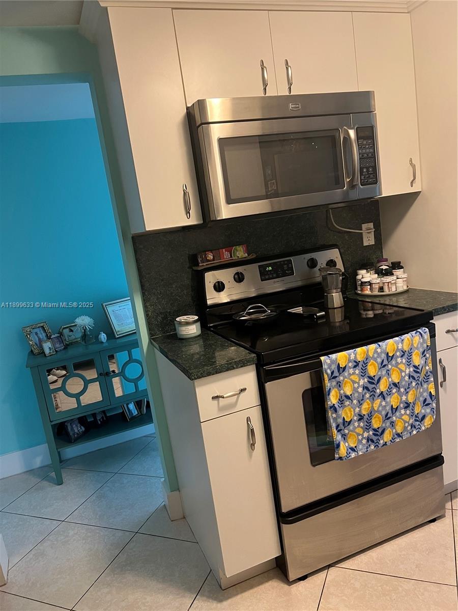 8335 Southwest 72nd Avenue, Unit 212D Miami, FL 33143 - Photo 11 of 31 a kitchen with a stove and a microwave