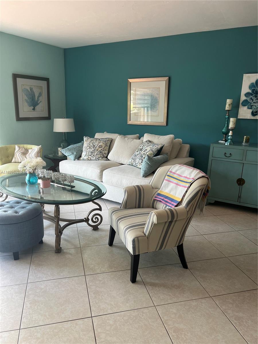 8335 Southwest 72nd Avenue, Unit 212D Miami, FL 33143 - Photo 4 of 31 a living room with furniture and wall paintings