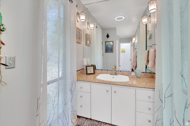 510 Spring Creek Road Providence, UT 84332 - Photo 22 of 97 Vanity featuring a rectangular basin, stone countertop, brushed nickel faucet, and a large wall-mounted mirror