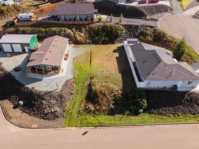 an aerial view of a house with a yard and lake view