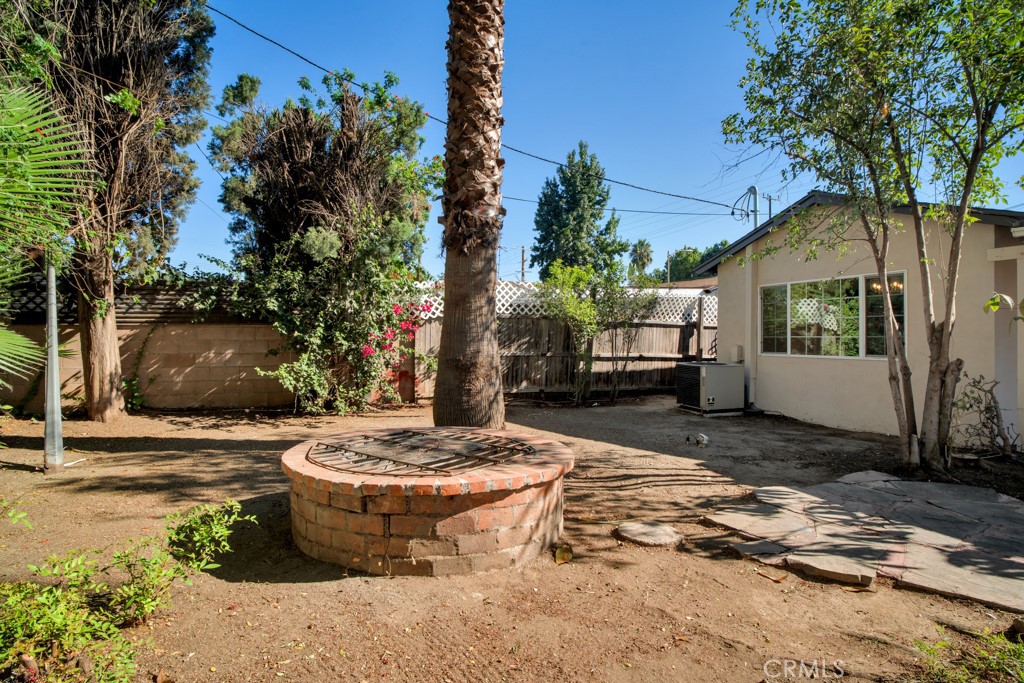 7635 Fallbrook Avenue West Hills, CA 91304 - Photo 23 of 26 a view of a backyard with table and chairs plants and trees