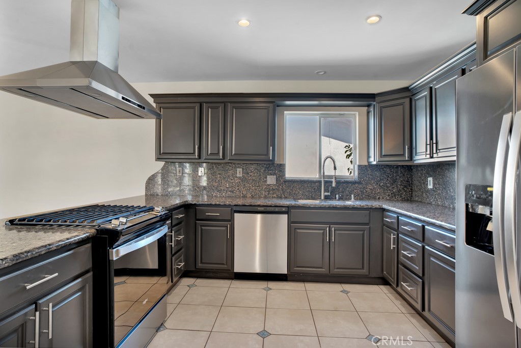 7635 Fallbrook Avenue West Hills, CA 91304 - Photo 4 of 26 a kitchen with granite countertop a sink stove and cabinets