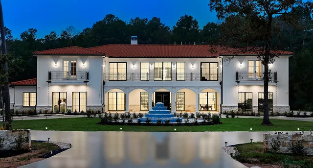 a front view of a house with a yard and a fountain