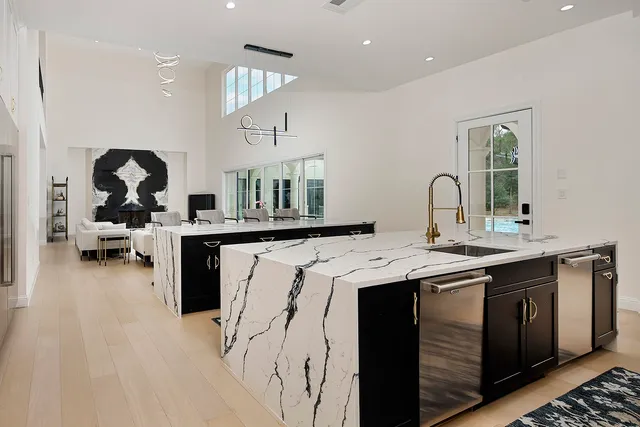 a kitchen with stainless steel appliances a sink a stove and a wooden floors