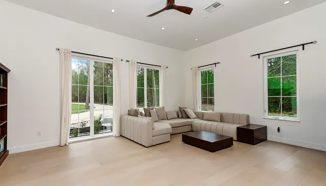 an empty room with kitchen and windows
