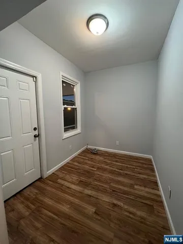 a view of a room with a bed and wooden floor