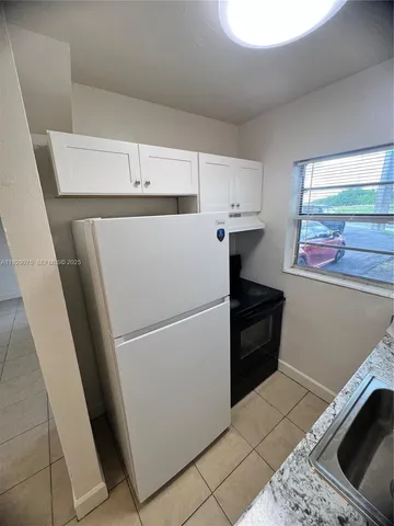 a white refrigerator freezer sitting inside of a kitchen