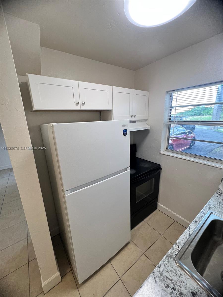 12905 Arch Creek Road, Unit 3 North Miami, FL 33161 - Photo 7 of 8 a white refrigerator freezer sitting inside of a kitchen