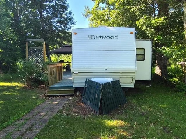 a view of a wooden bench sitting in the grass