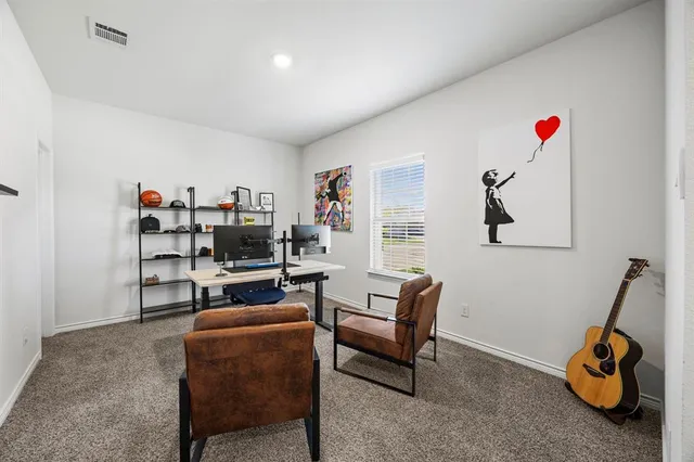 a living room with furniture and a gym machine