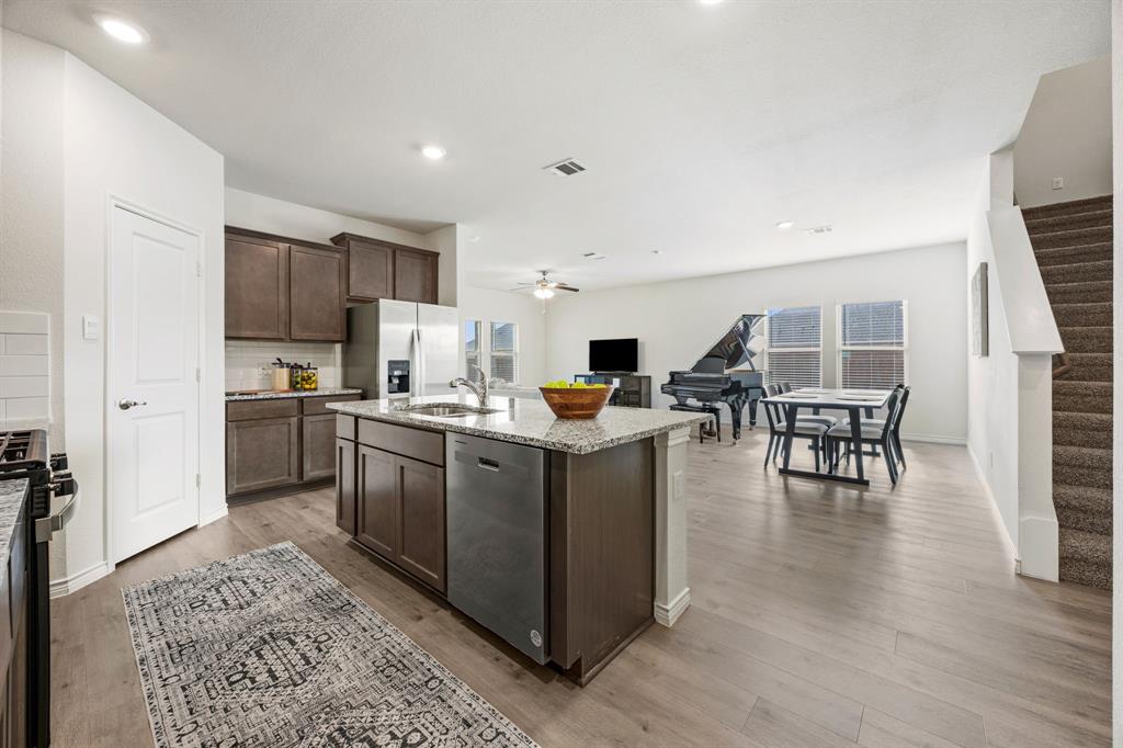700 Cool Cyn Trail Princeton, TX 75407 - Photo 7 of 18 a kitchen with stainless steel appliances kitchen island granite countertop a stove top oven a sink a dining table and chairs