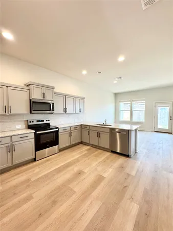 a large kitchen with a stove top oven and sink