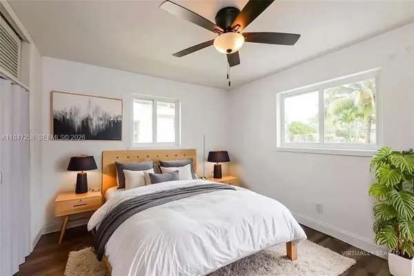 a bedroom with a large bed and a potted plant