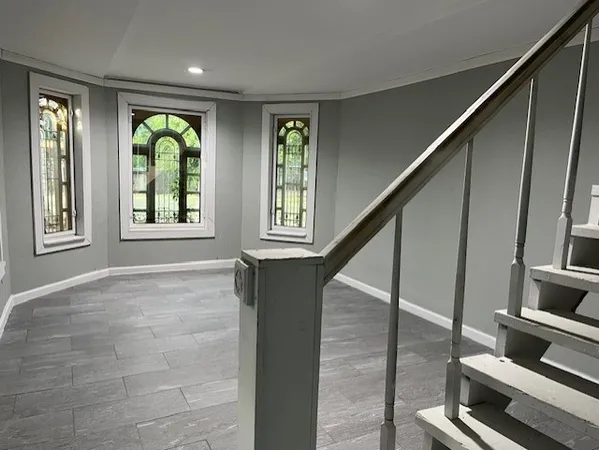 a view of an entryway with wooden floor windows and a chandelier