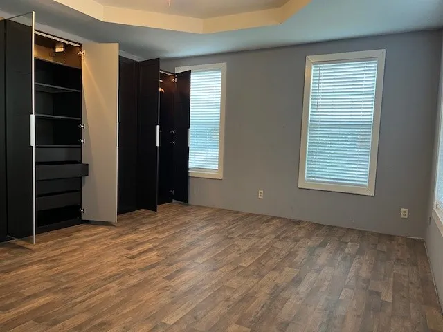 a view of an empty room with closet and a window