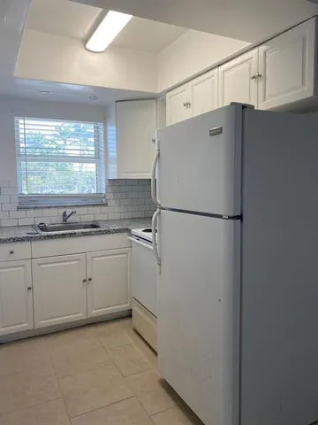 a kitchen with a refrigerator and a sink