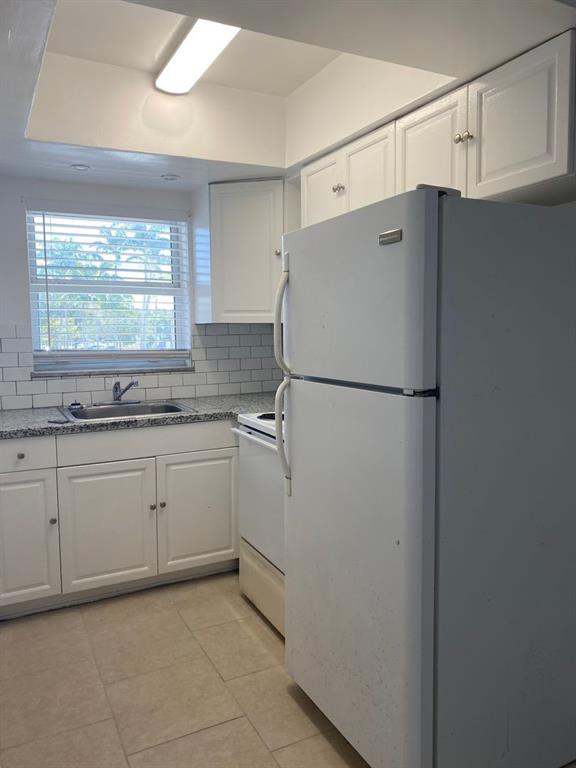 a kitchen with a refrigerator and a sink