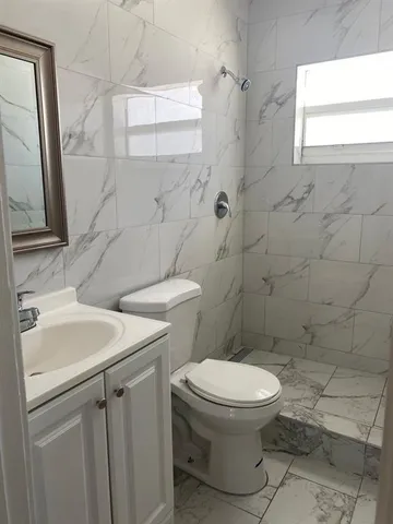 a bathroom with a toilet sink and a mirror