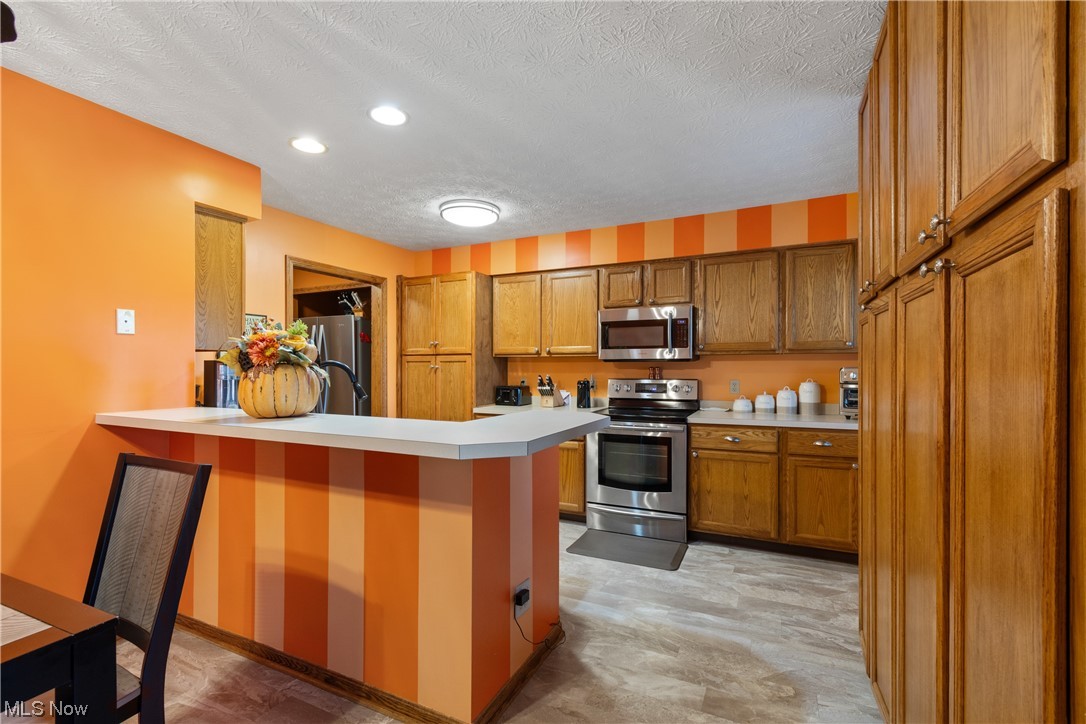 8366 Turquoise Avenue Northeast Canton, OH 44721 - Photo 6 of 26 Kitchen featuring kitchen peninsula, updated stainless steel appliances and an abundance of cabinet space.