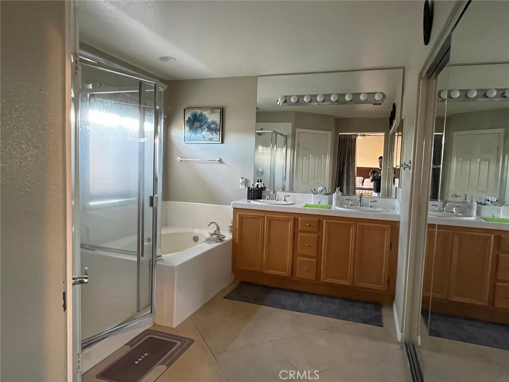 24336 Caladium Place Valencia, CA 91354 - Photo 10 of 25 a spacious bathroom with a tub sink and mirror