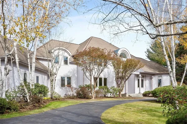 a front view of residential houses with yard and trees