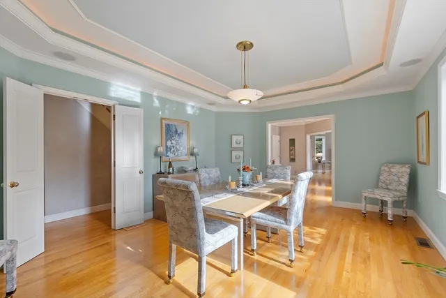 a dining room with furniture a chandelier and wooden floor