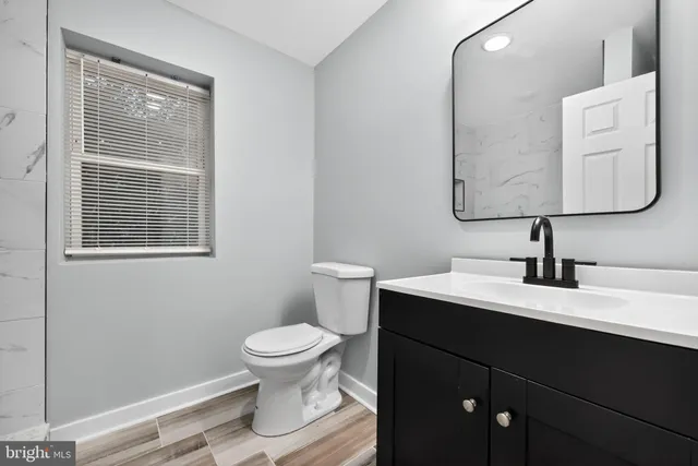 a view of an empty room with wooden floor and stairs