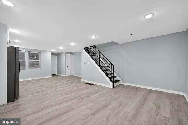 an empty room with wooden floor and white walls