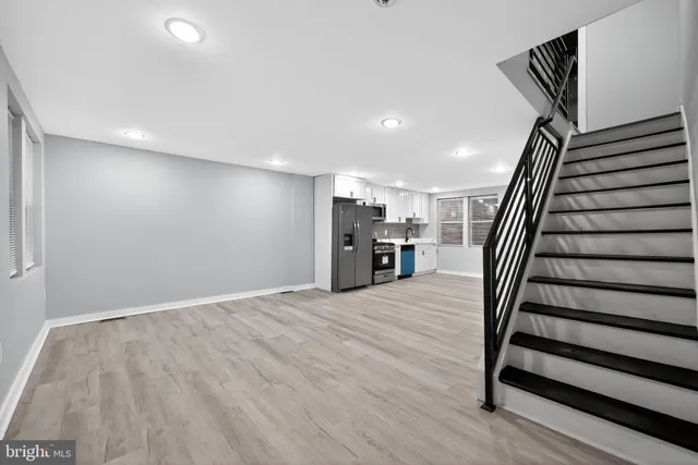 a view of a livingroom with wooden floor and stairs