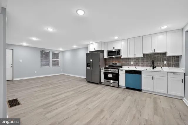 a kitchen with stainless steel appliances granite countertop a stove a sink and a refrigerator