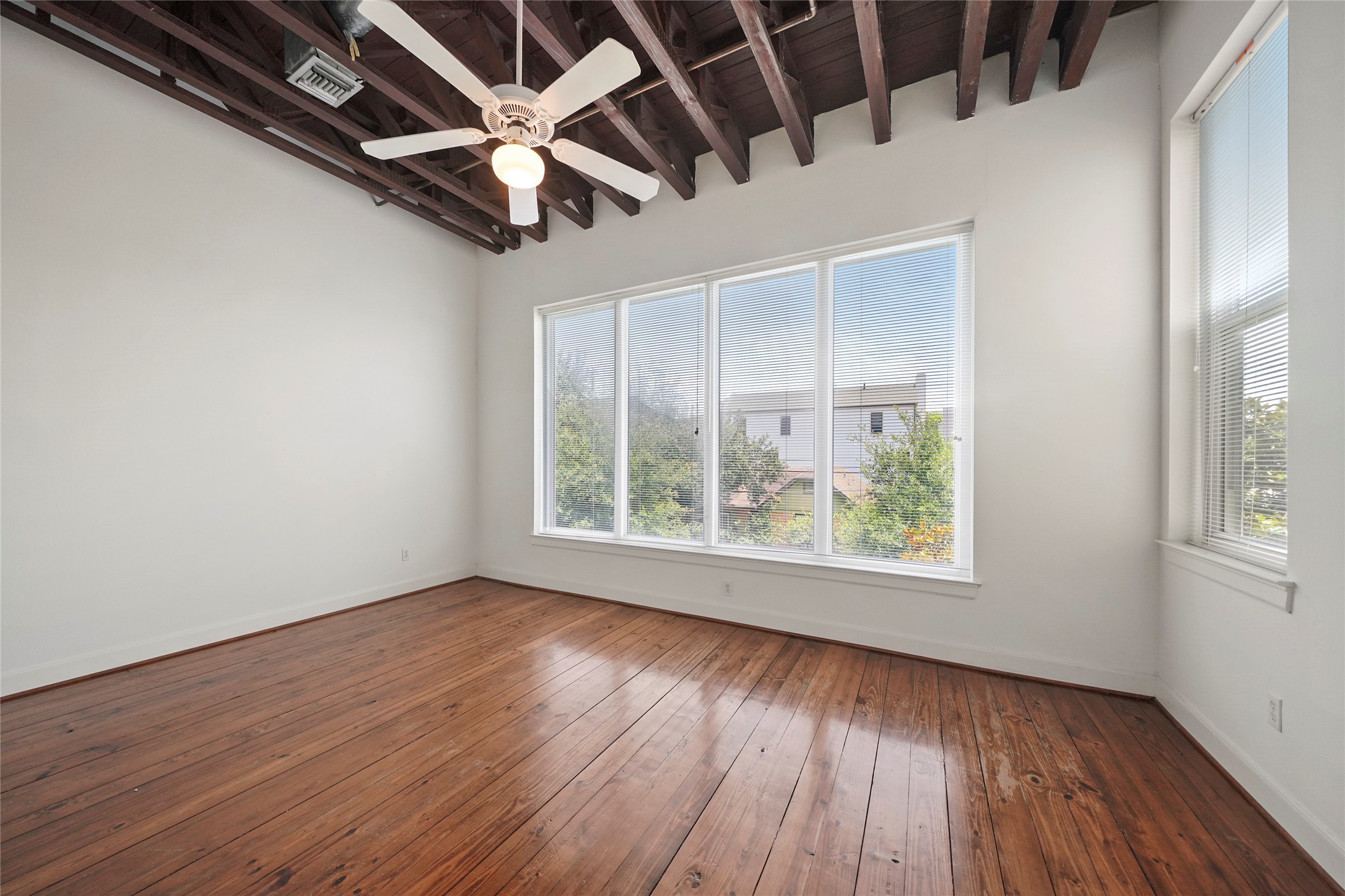 1514 Stanford Street Houston, TX 77019 - Photo 23 of 34 an empty room with wooden floor chandelier fan and windows