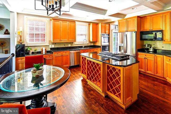 20366 Fallsway Terrace Sterling, VA 20165 - Photo 16 of 45 a kitchen with stainless steel appliances granite countertop a stove a sink and a dining table with chairs