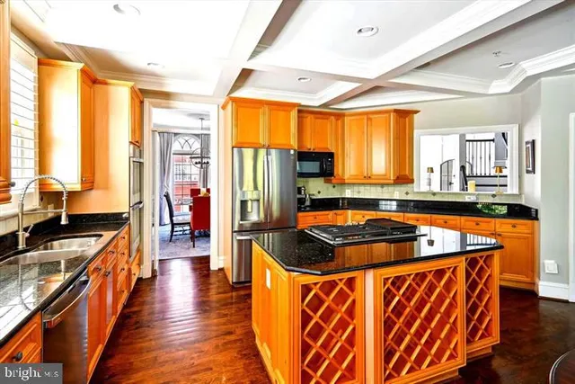 a kitchen with stainless steel appliances granite countertop a sink a stove and a refrigerator