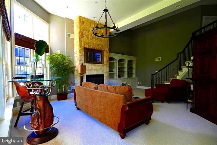 20366 Fallsway Terrace Sterling, VA 20165 - Photo 36 of 45 a living room with furniture a fireplace and a chandelier