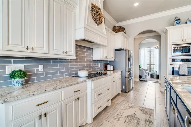 a kitchen with granite countertop a sink a counter space cabinets and stainless steel appliances