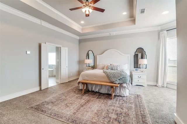 a bedroom with a large bed and a chandelier