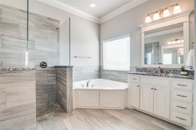 a bathroom with a double vanity sink a mirror and a bathtub