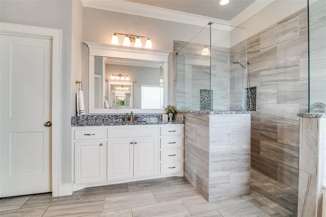 a bathroom with a granite countertop sink mirror and shower