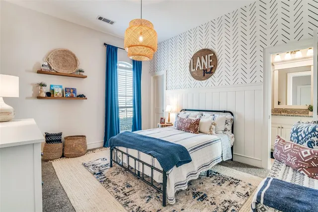 a bedroom with a bed and a lamp on dresser