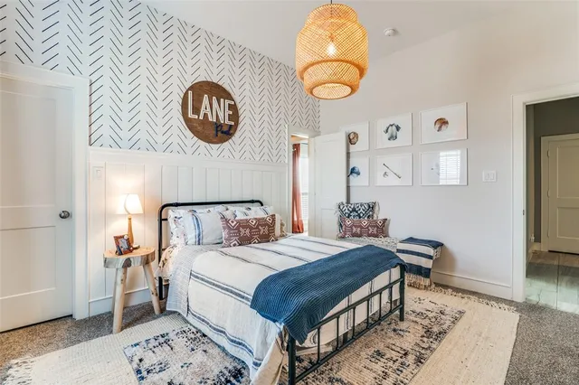 a bedroom with a bed and a lamp on dresser