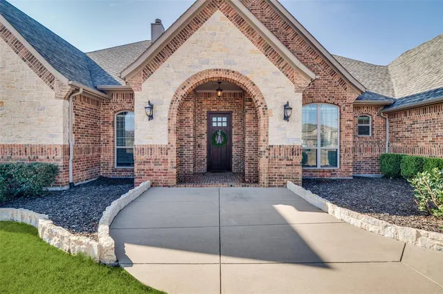 a view of a house with brick walls and a yard