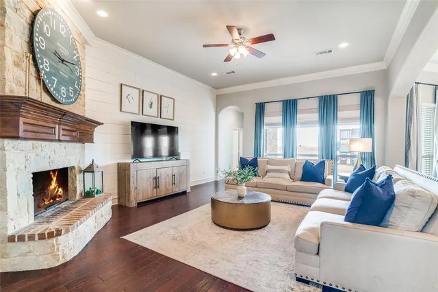 a living room with furniture a fireplace and a floor to ceiling window