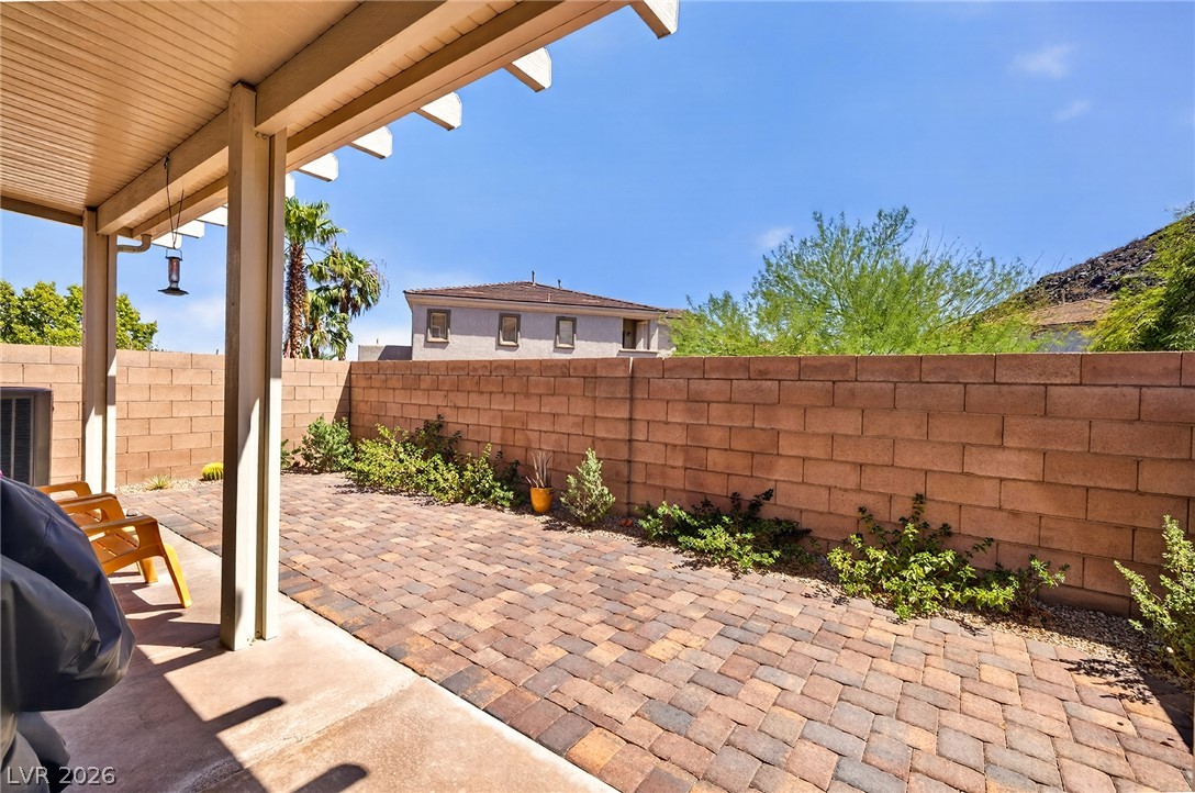 226 Priority Point Street Henderson, NV 89012 - Photo 12 of 32 An inviting covered patio opens directly onto a private paver courtyard bordered by high block walls.