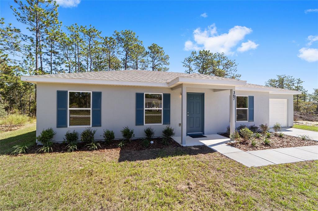 76 Alvarez Road Dunnellon, FL 34431 - Photo 1 of 1 a front view of a house with a yard and seating space