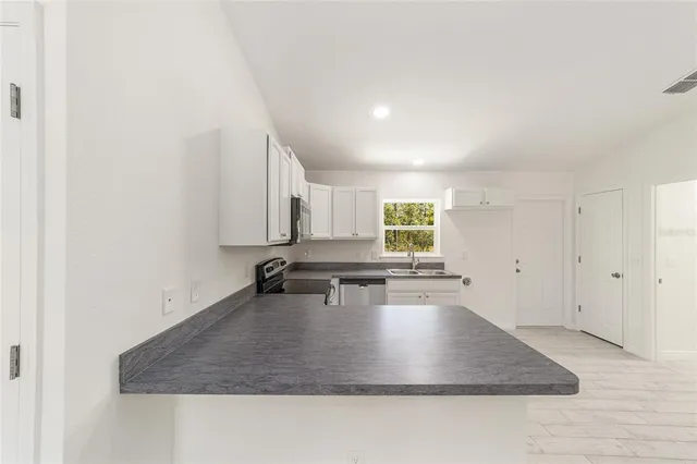 a kitchen with stainless steel appliances granite countertop a sink stove and cabinets